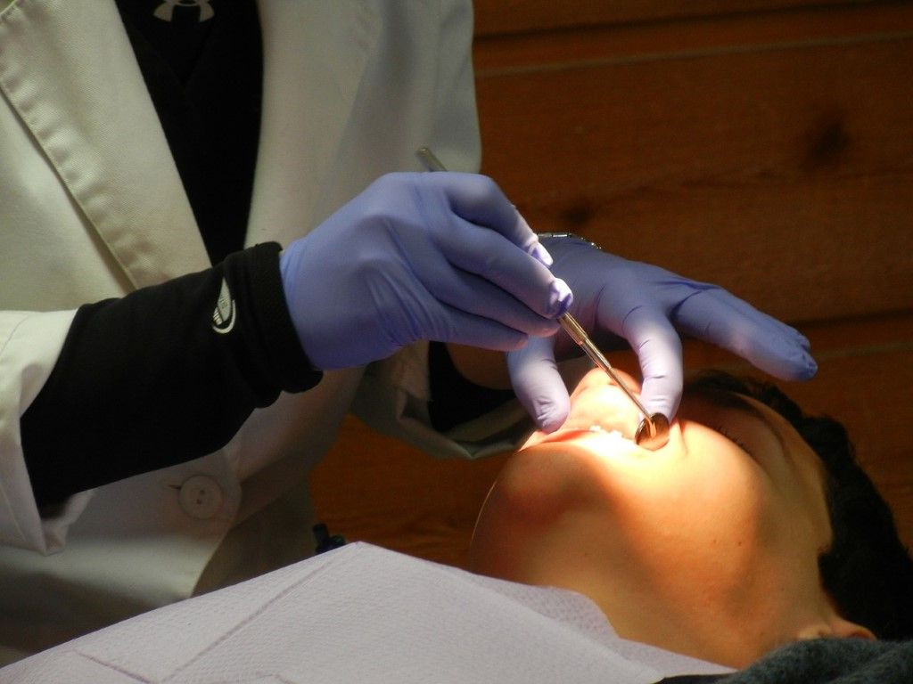 Die Untersuchung eines Patienten durch einen Zahnarzt unter Licht